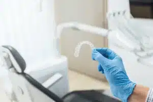 a dentist holding a clear aligner