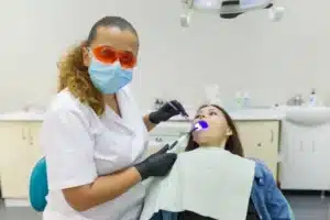 An adult dentist with a woman for dental treatment
