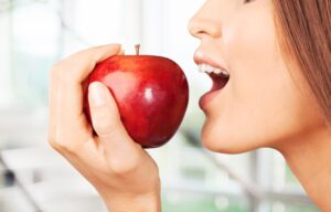 woman about to bite an apple